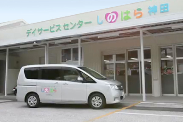 デイサービスセンターしのはら神田外観。建物の前に施設の車が停まっている。